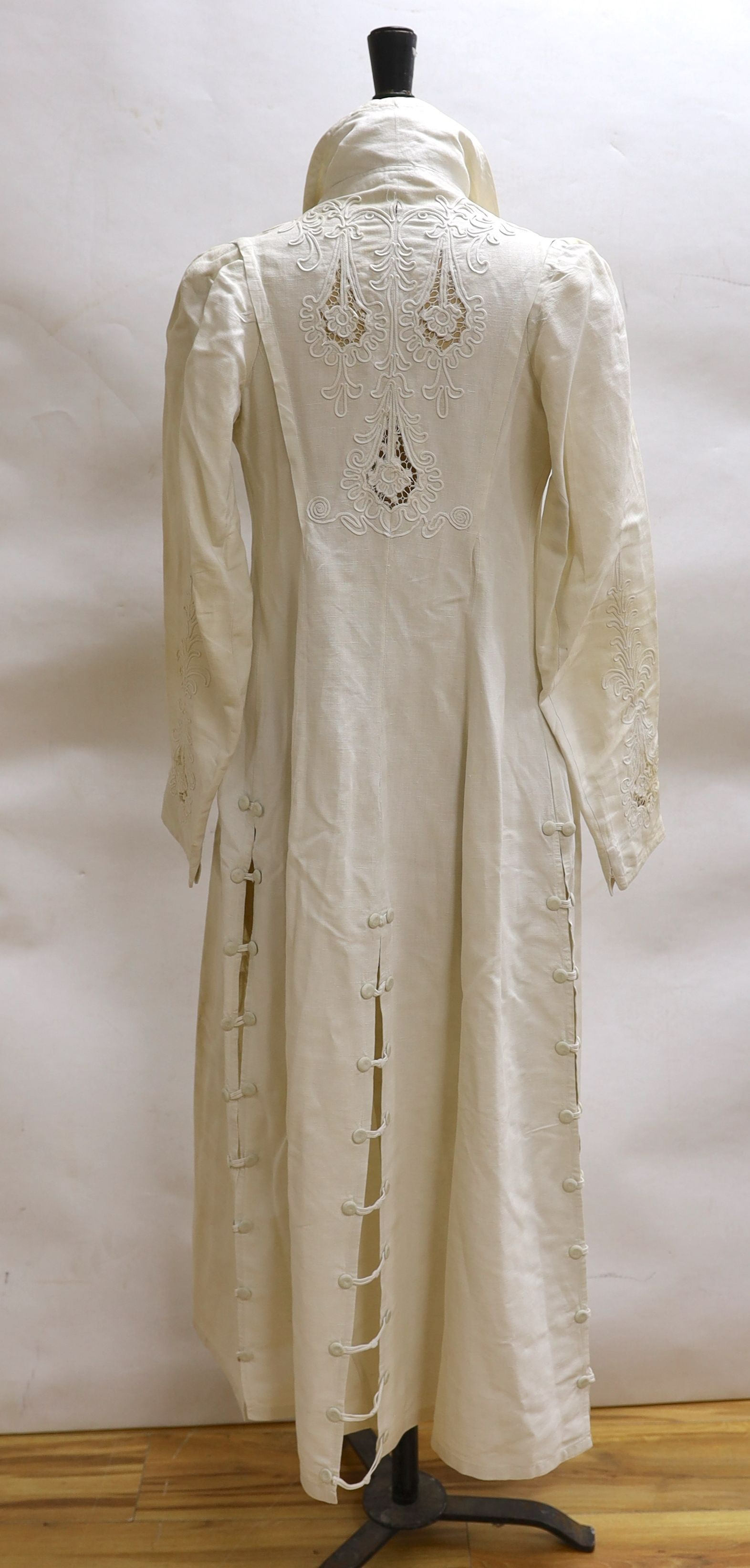 An Edwardian white/cream linen lady's coat with cut work detail and unusual button detail to the back